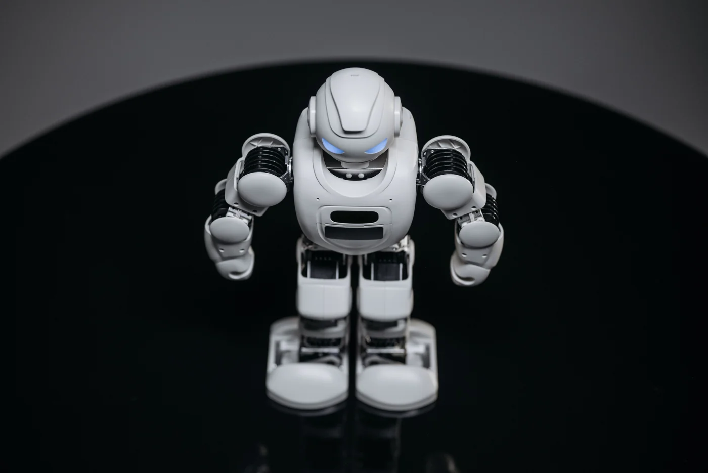 Robot de juguete blanco sobre una superficie oscura